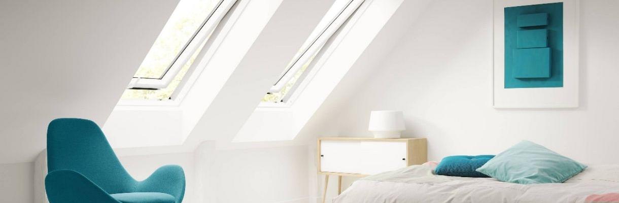 VELUX dakraam maten in een lichte slaapkamer met twee grote dakramen en veel natuurlijk daglicht.